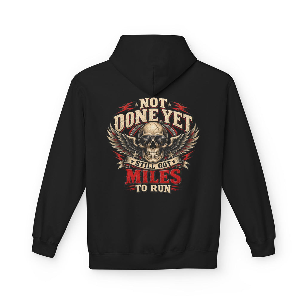 A black pullover hoodie shown from the back, featuring a large graphic print of a skull with wings and the text 'NOT DONE YET', 'STILL GOT', 'MILES TO RUN' in cream, red, and black.