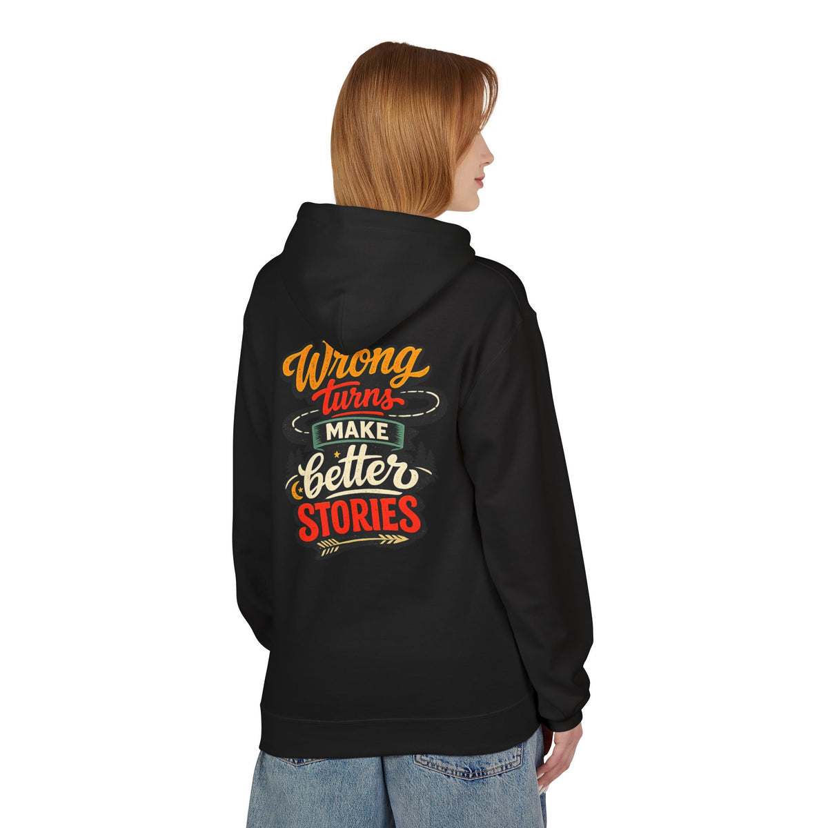 A woman shown from the back wearing a black hoodie with a colorful graphic 'WRONG TURNS MAKE BETTER STORIES text print on the back, paired with light blue jeans, against a plain white background.