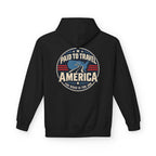 A black pullover hoodie shown from the back, featuring a circular graphic print with the text 'PAID TO TRAVEL AMERICA' and 'THE ROAD IS THE JOB' in cream, blue, and red.