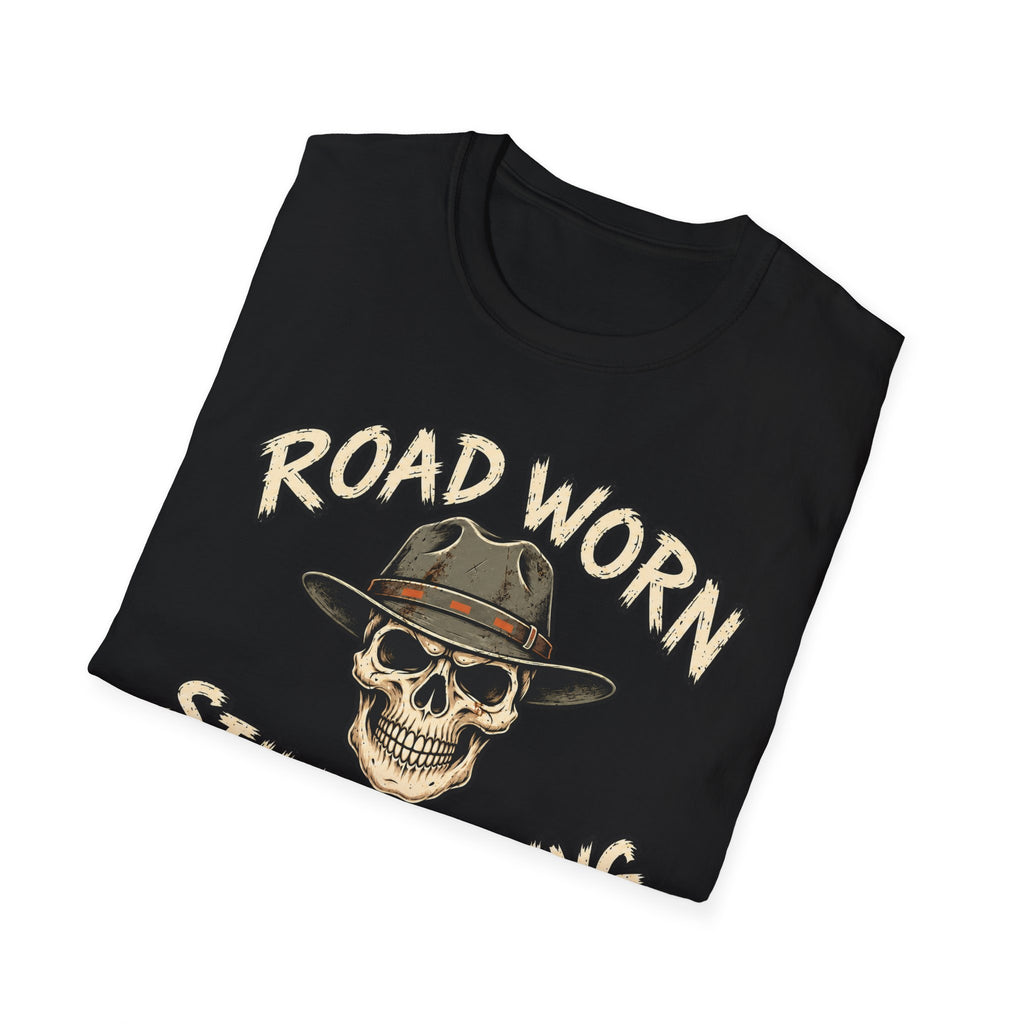 A folded black t-shirt with a graphic print of a skull wearing a cowboy hat and the text 'ROAD WORN STILL ROLLING' in a distressed beige font, shown on a plain white background.