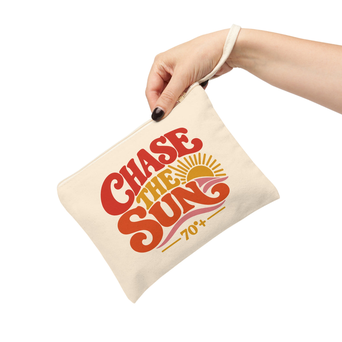 A hand holding a cream canvas pouch with a retro-style 'Chase the Sun 70+' graphic in red, orange, and yellow on a white background.