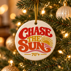 A "Chase the Sun" ornament hanging on a Christmas tree with Christmas ball ornaments and lights.