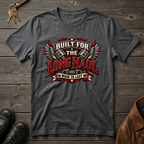 A dark gray heather crewneck t-shirt with a vintage-style graphic reading 'BUILT FOR THE LONG HAUL MADE TO LAST' in red, white, and black, styled flat on a rustic wooden background with keys, shoes, and a leather jacket nearby.