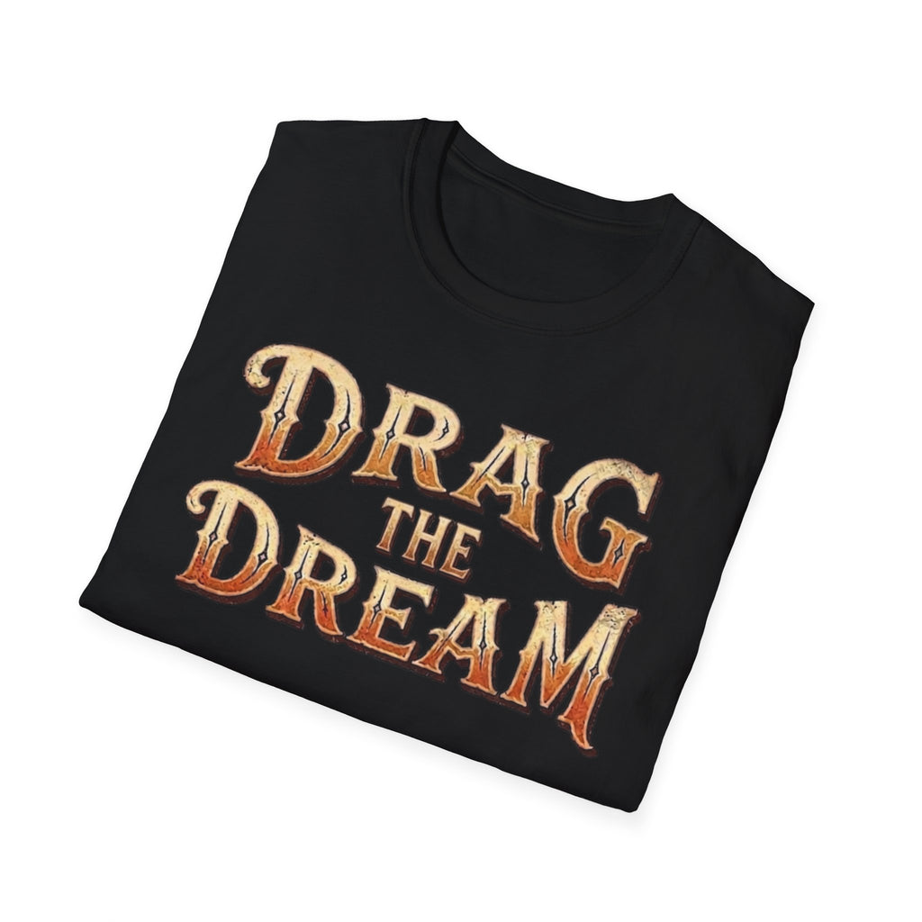 A black folded t-shirt with a distressed graphic reading 'DRAG THE DREAM' in orange and beige lettering, displayed on a clean white background.