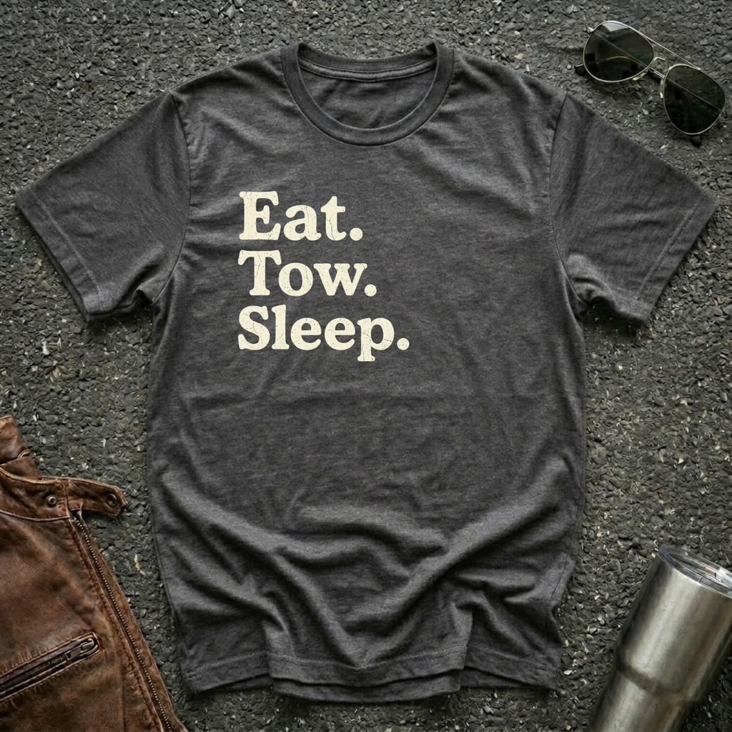 A dark heather crewneck t-shirt with the text 'Eat. Tow. Sleep.' flat lay.