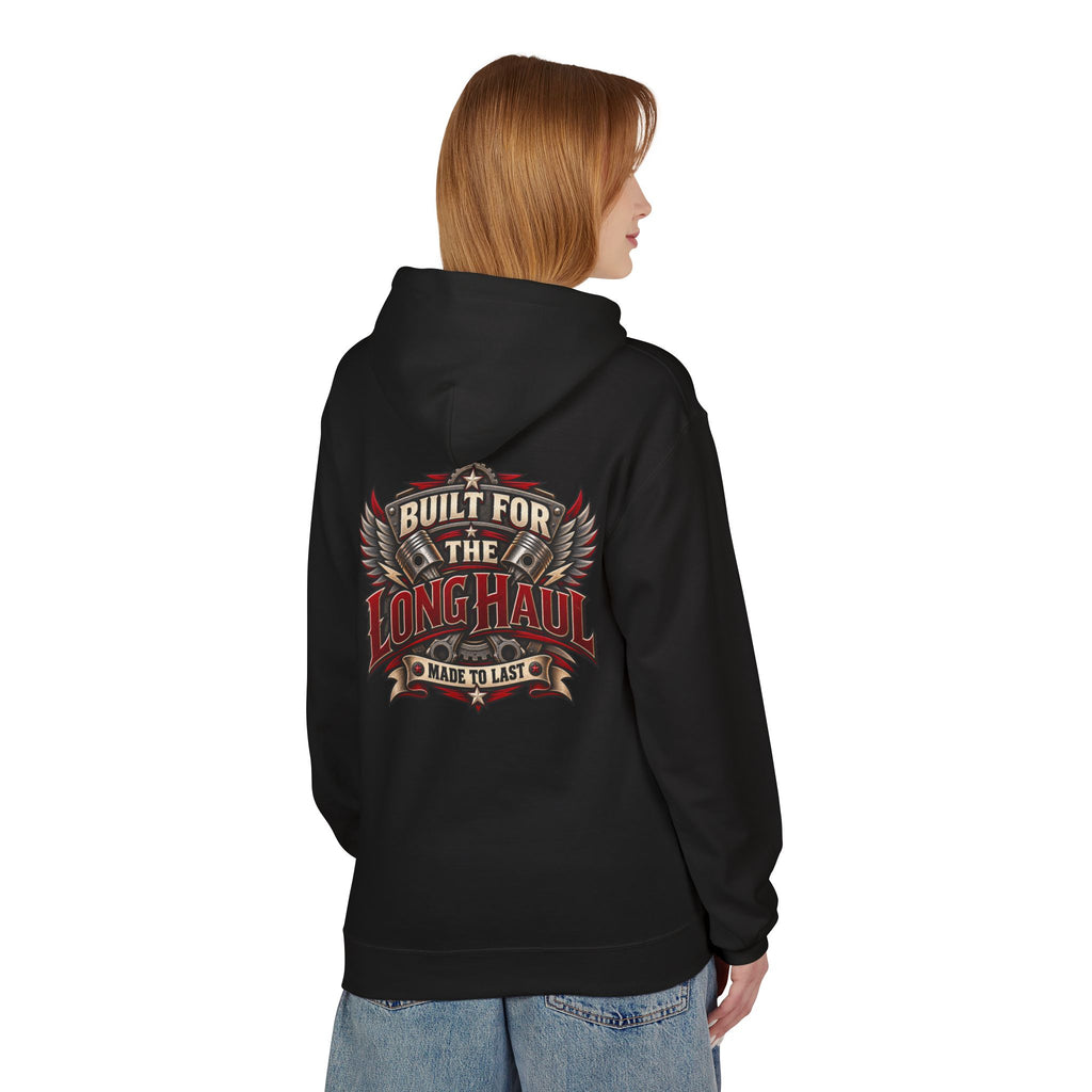 A woman shown from the back wearing a black hoodie with a large graphic print on the back that reads 'Built for the Long Haul' and 'No Mile to Last' in red, beige, and white. She is also wearing blue jeans against a plain white background.