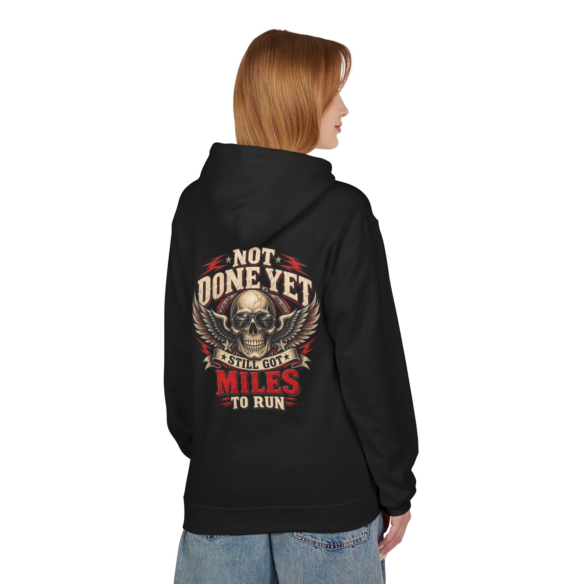 A woman shown from the back wearing a black hoodie with a large graphic print on the back. The graphic features a skull with wings and the text 'NOT DONE YET', 'STILL GOT MILES TO RUN'