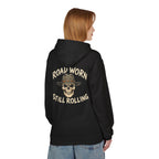 Person wearing a black hoodie with text on the back 'Road Worn Still Rolling' standing against a white background