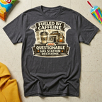 Fueled by Caffeine and Questionable Gas Station Decisions T-shirt by The Riverstone Life on a dark heather Gildan Softstyle 64000 featuring a coffee cup, gas station, and humorous road trip design.