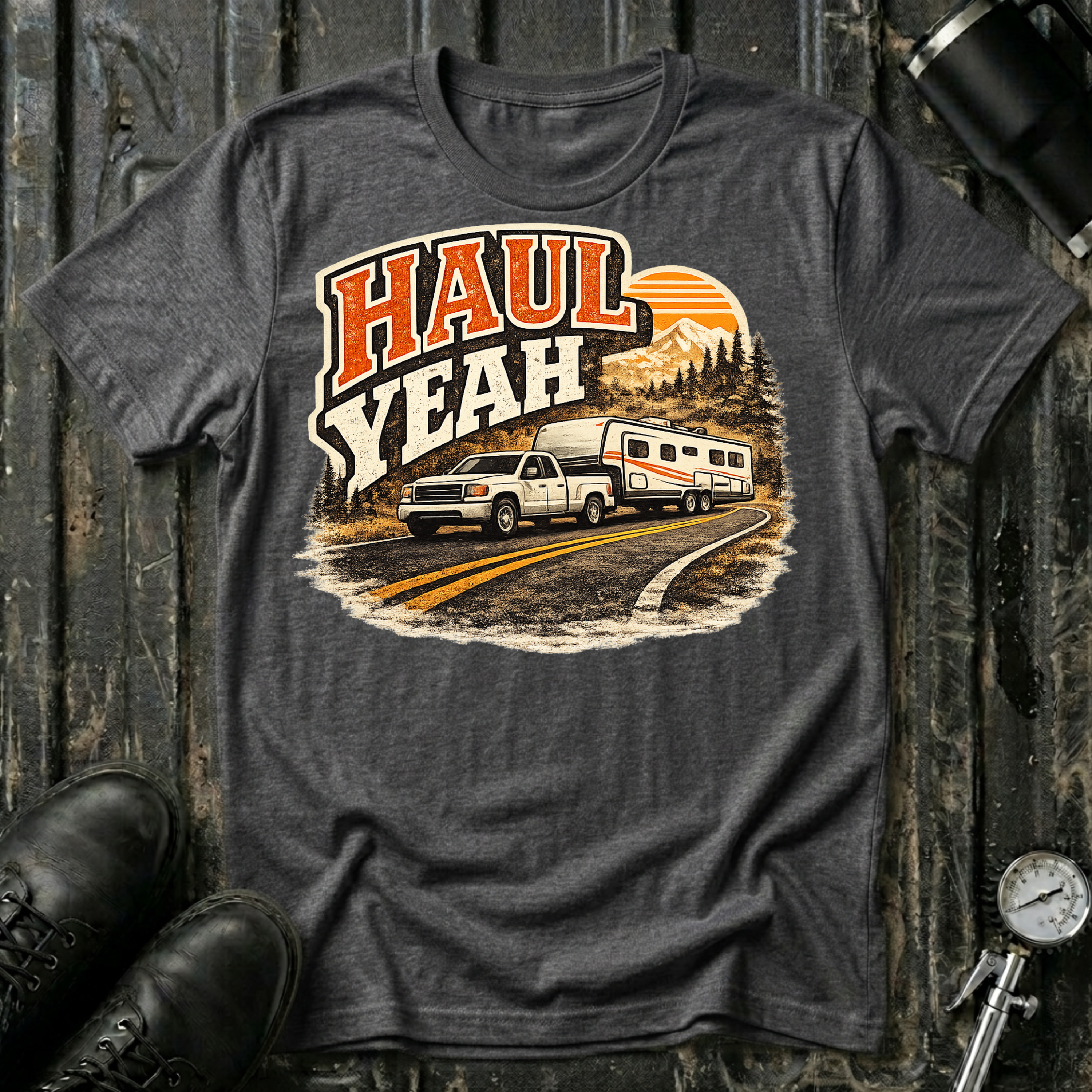 Haul Yeah RV Transport T-shirt by The Riverstone Life on a dark heather Gildan Softstyle 64000 featuring a pickup truck towing a fifth-wheel RV.