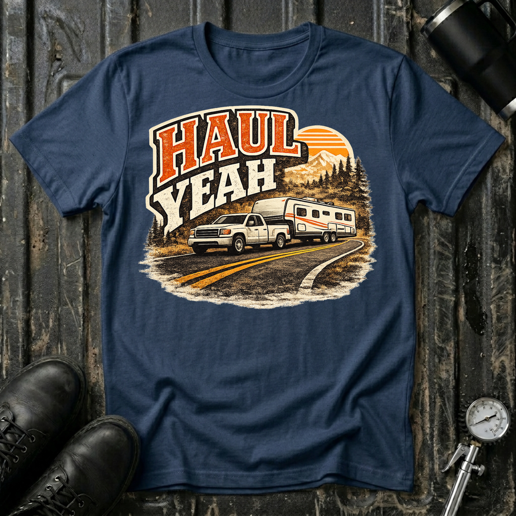 Haul Yeah RV Transport T-shirt by The Riverstone Life on a navy blue Gildan Softstyle 64000 featuring a pickup truck towing a fifth-wheel RV.