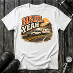 Haul Yeah RV Transport T-shirt by The Riverstone Life on a white Gildan Softstyle 64000 featuring a pickup truck towing a fifth-wheel RV.
