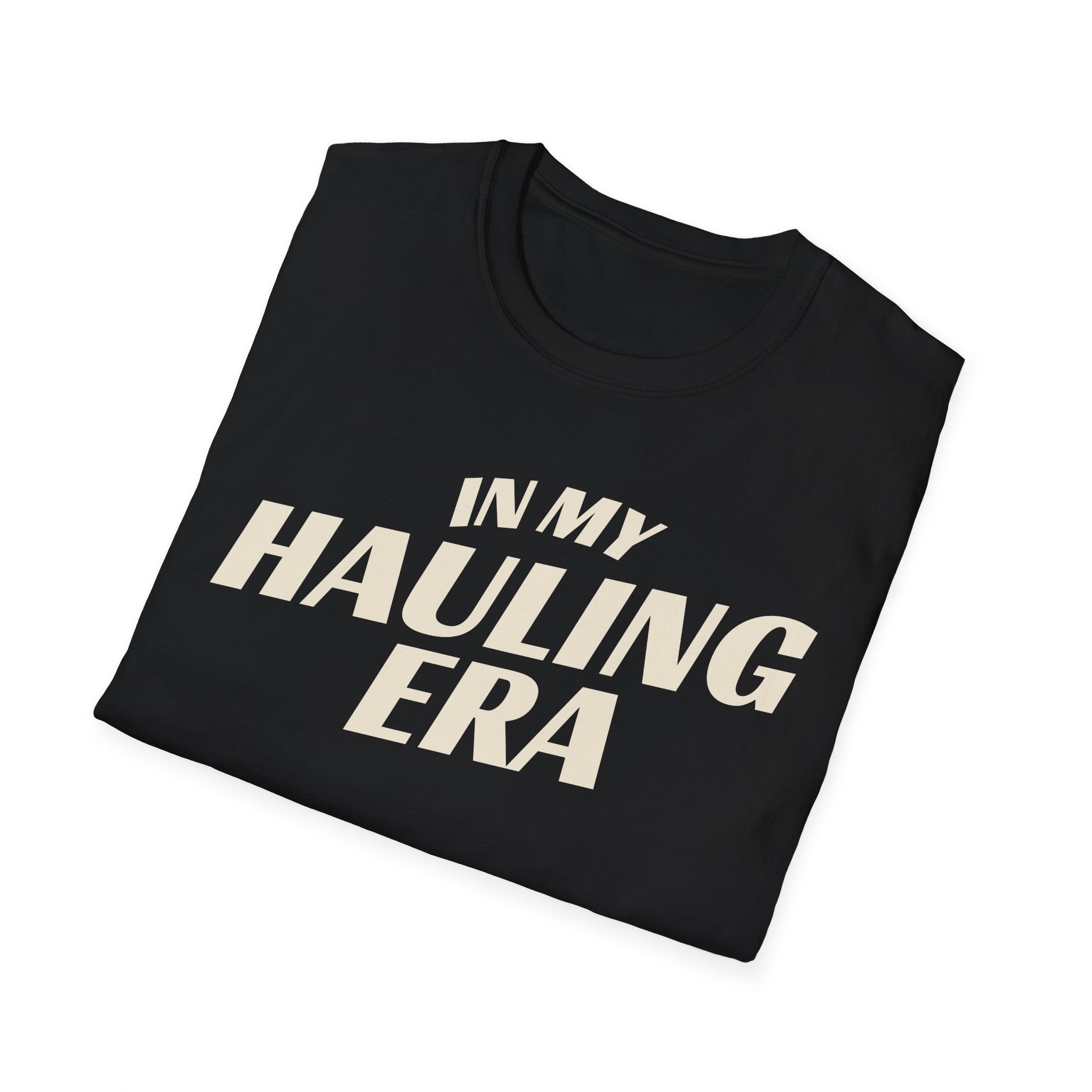 Folded black 'In My Hauling Era' road life t-shirt featuring bold cream typography on a soft unisex tee.