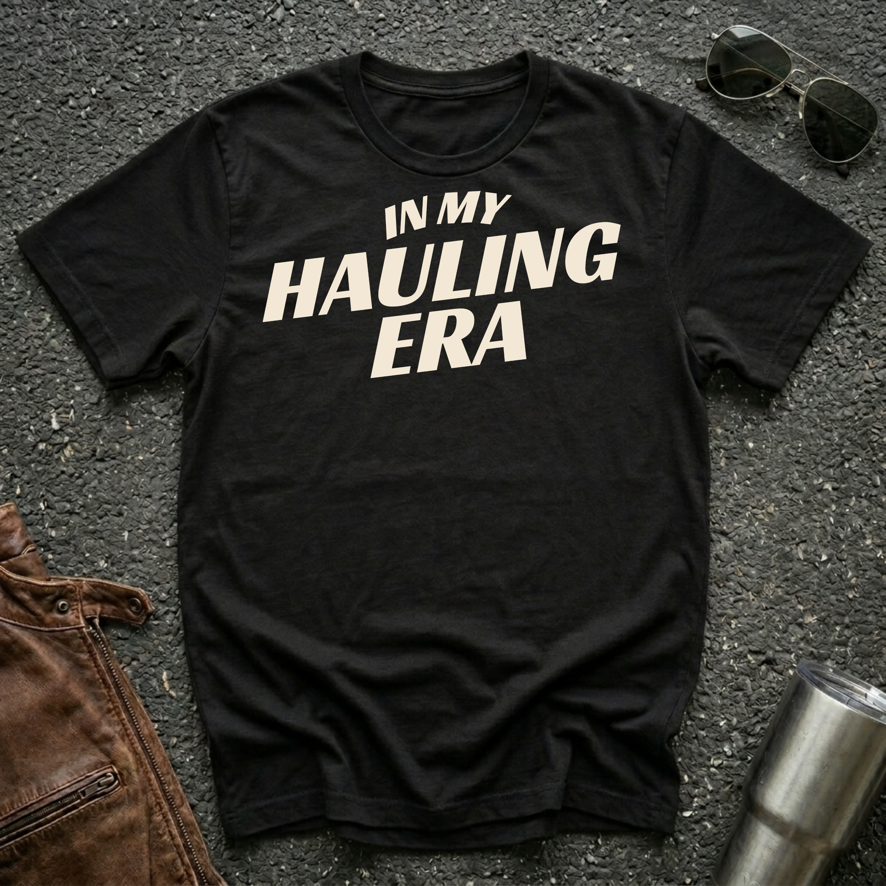Black 'In My Hauling Era' road life t-shirt featuring bold cream typography on a soft unisex tee.