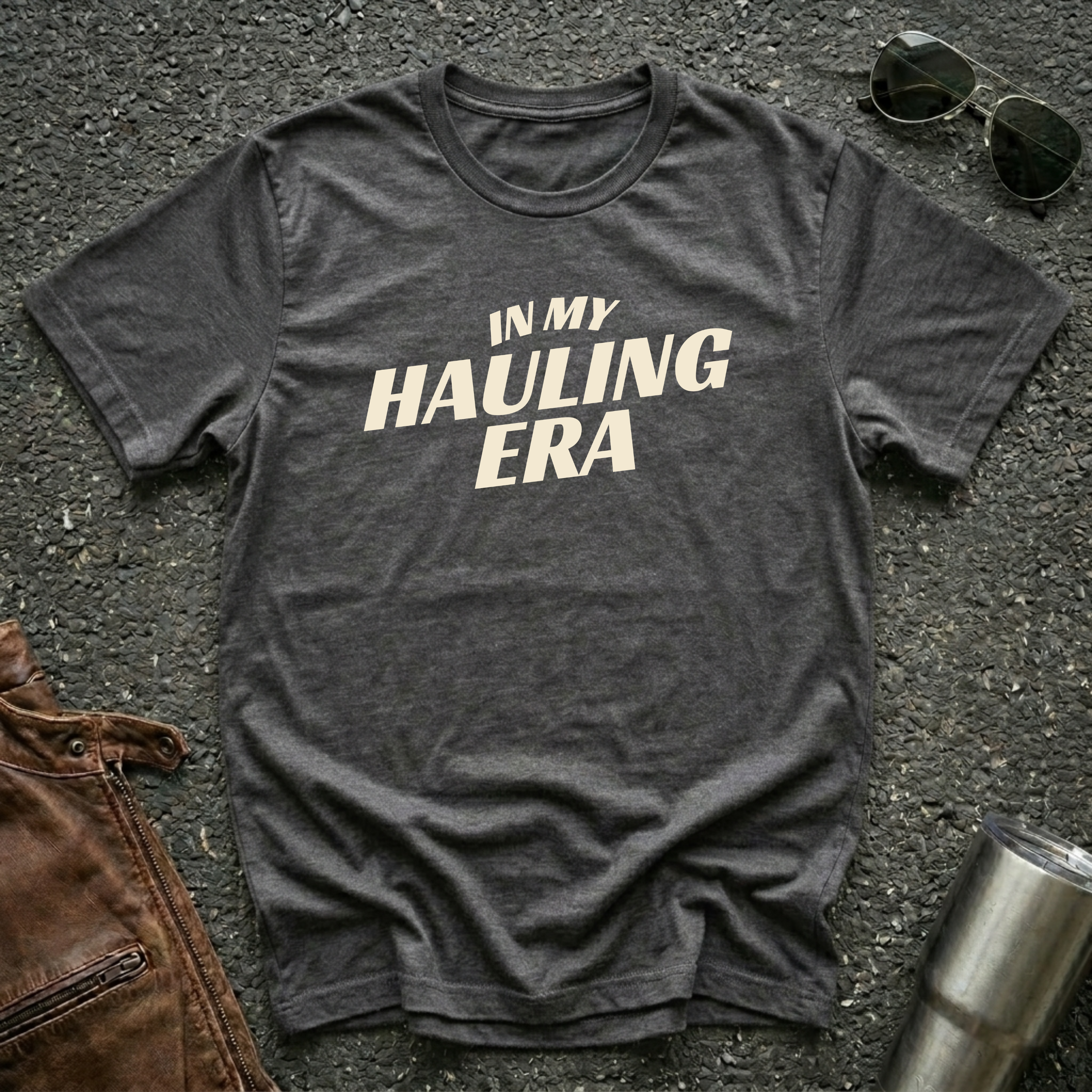 Dark heather 'In My Hauling Era' road life t-shirt featuring bold cream typography on a soft unisex tee.