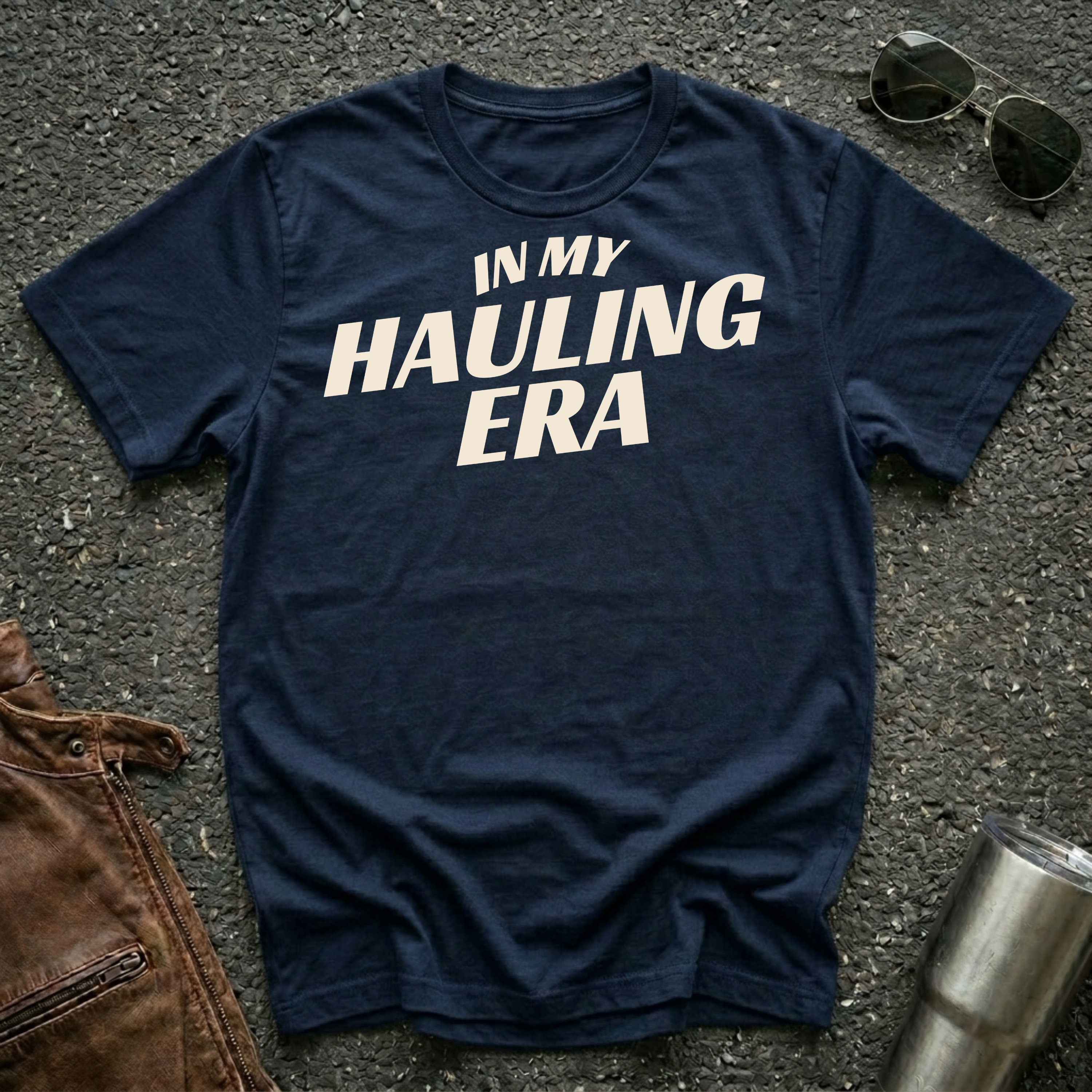 Navy 'In My Hauling Era' road life t-shirt featuring bold cream typography on a soft unisex tee.