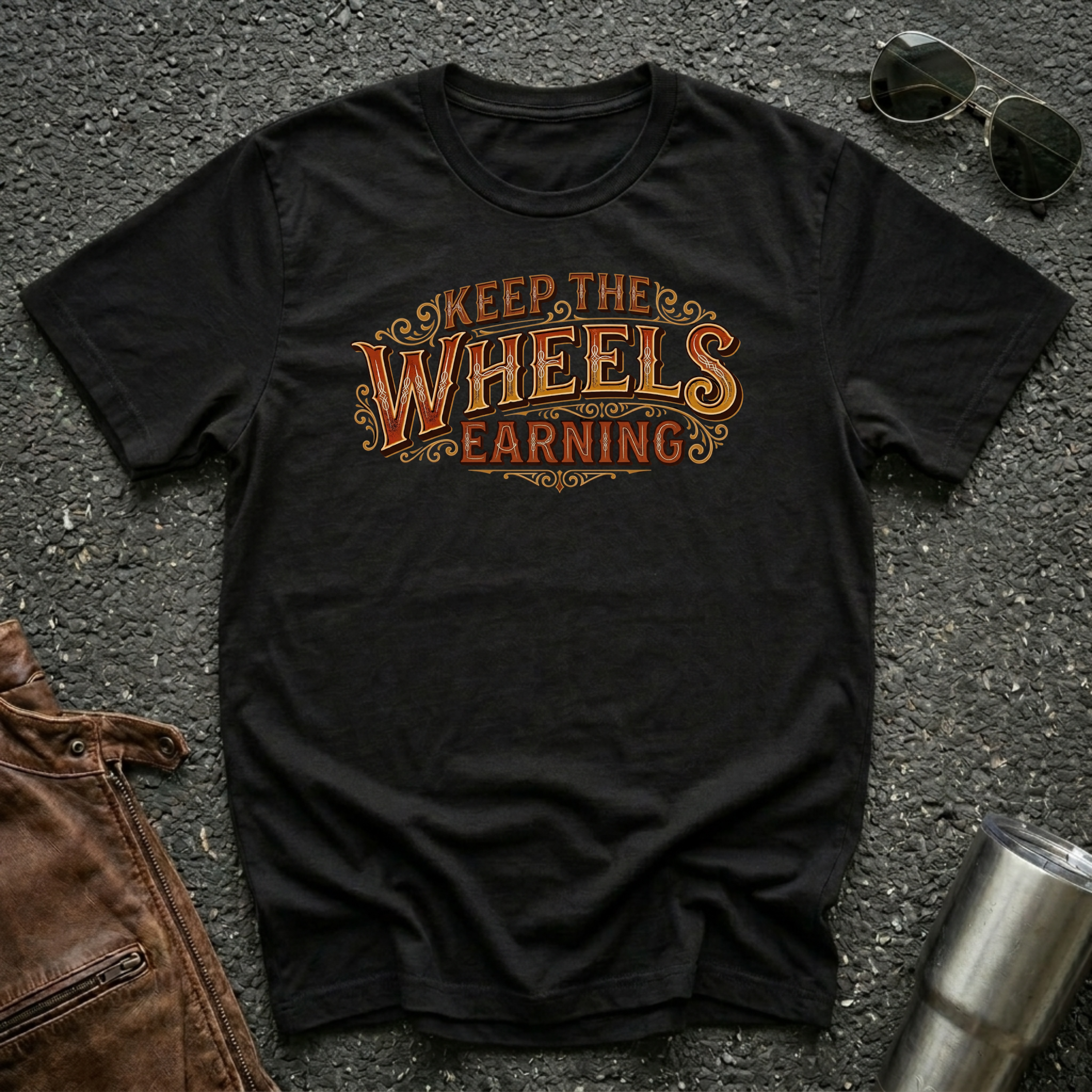 Black 'Keep The Wheels Earning Vintage' RV Transport T-shirt featuring vintage gold and rust typography on a soft unisex tee.