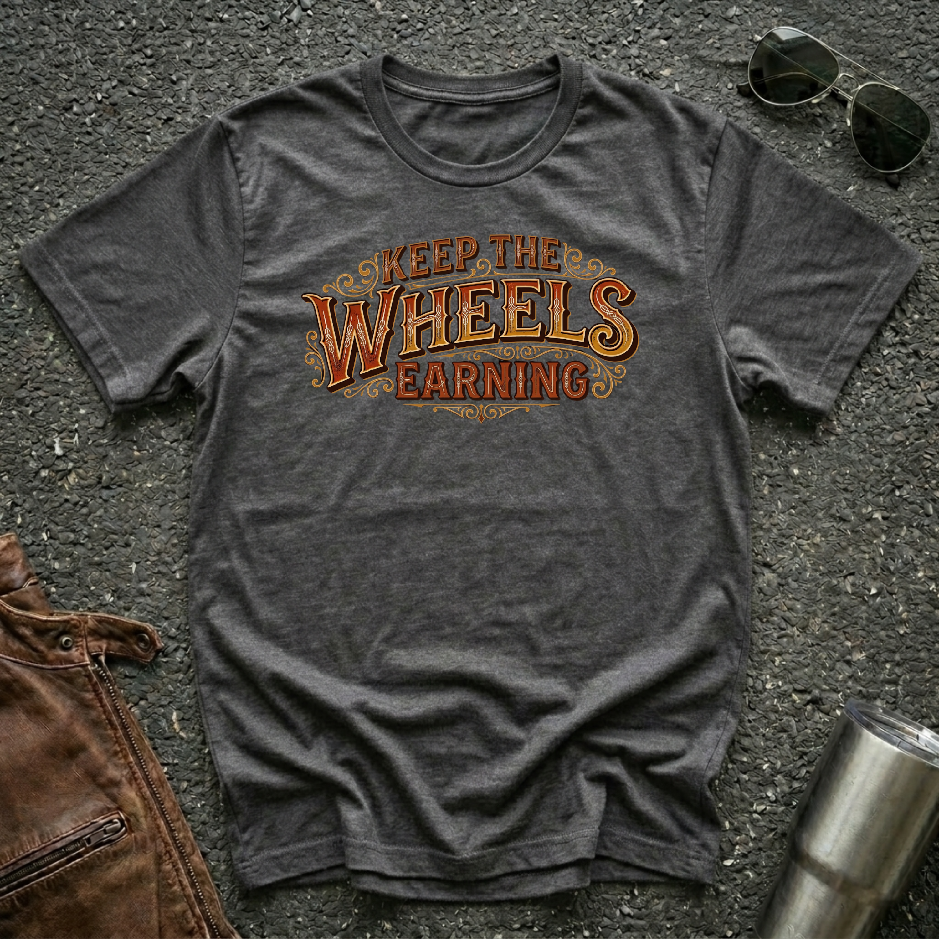 Dark heather 'Keep The Wheels Earning Vintage' RV Transport T-shirt featuring vintage gold and rust typography on a soft unisex tee.