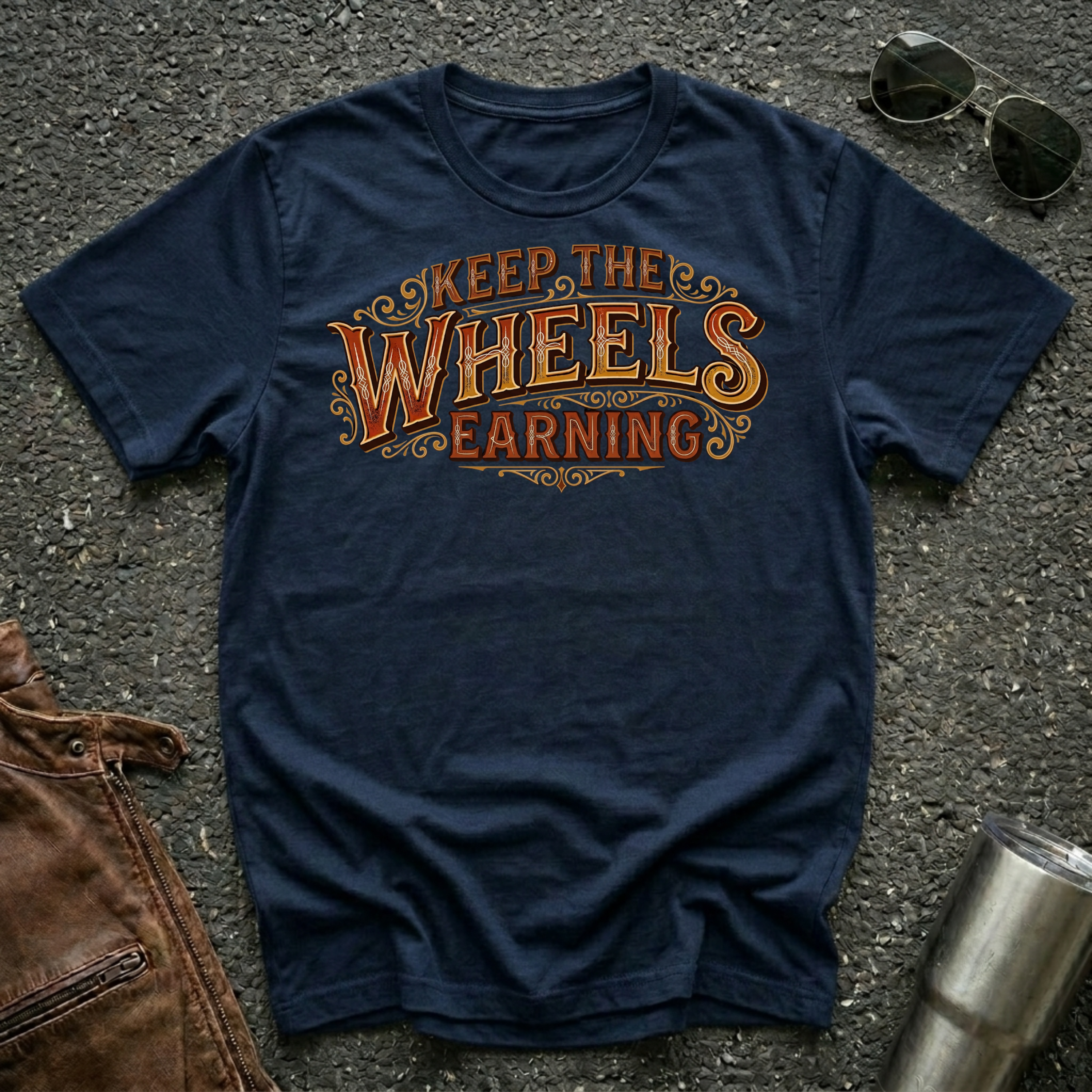 Navy 'Keep The Wheels Earning' Vintage RV Transport T-shirt featuring vintage gold and rust typography on a soft unisex tee.