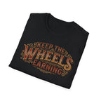Black folded 'Keep The Wheels Earning' vintage RV Transport T-shirt featuring vintage gold and rust typography on a soft unisex tee on a white background.