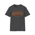 Dark heather 'Keep The Wheels Earning' vintage RV Transport T-shirt featuring vintage gold and rust typography on a soft unisex tee on a white background.