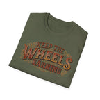 Military green folded 'Keep The Wheels Earning' vintage RV Transport T-shirt featuring vintage gold and rust typography on a soft unisex tee on a white background.
