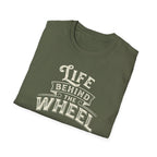 A black short-sleeve t-shirt with a distressed cream graphic reading 'LIFE BEHIND THE WHEEL' folded white background
