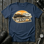 Loaded Up & Pointed West T-shirt by The Riverstone Life on a navy Gildan Softstyle 64000 featuring a pickup truck towing a camper RV toward a western sunset.