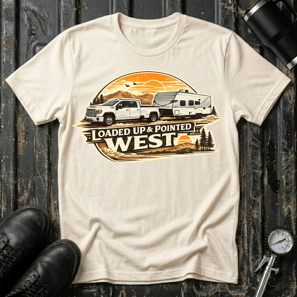 Loaded Up & Pointed West T-shirt by The Riverstone Life on a natural Gildan Softstyle 64000 featuring a pickup truck towing a camper toward a western sunset.