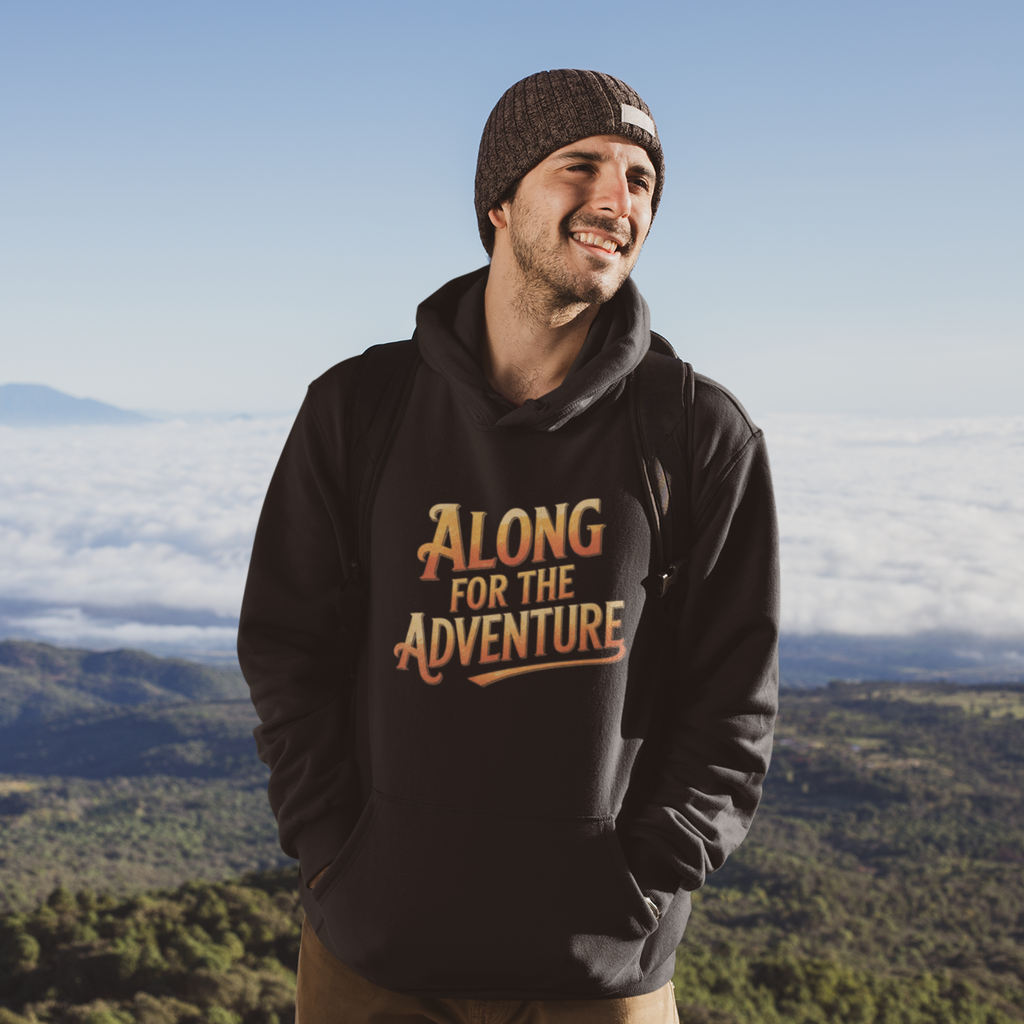 A man wearing a black hoodie with the text 'ALONG FOR THE ADVENTURE' in orange and yellow, standing outdoors with a mountain and cloud landscape in the background.