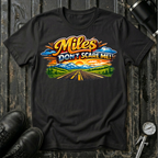 Miles Don't Scare Me! T-shirt by The Riverstone Life on a black Gildan Softstyle 64000 featuring a colorful open highway and mountain landscape design.