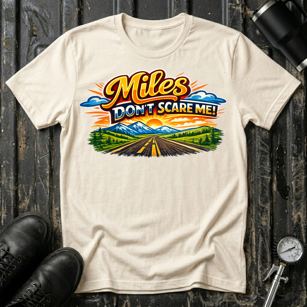 Miles Don't Scare Me! T-shirt by The Riverstone Life on a natural Gildan Softstyle 64000 featuring a colorful open highway and mountain landscape design.
