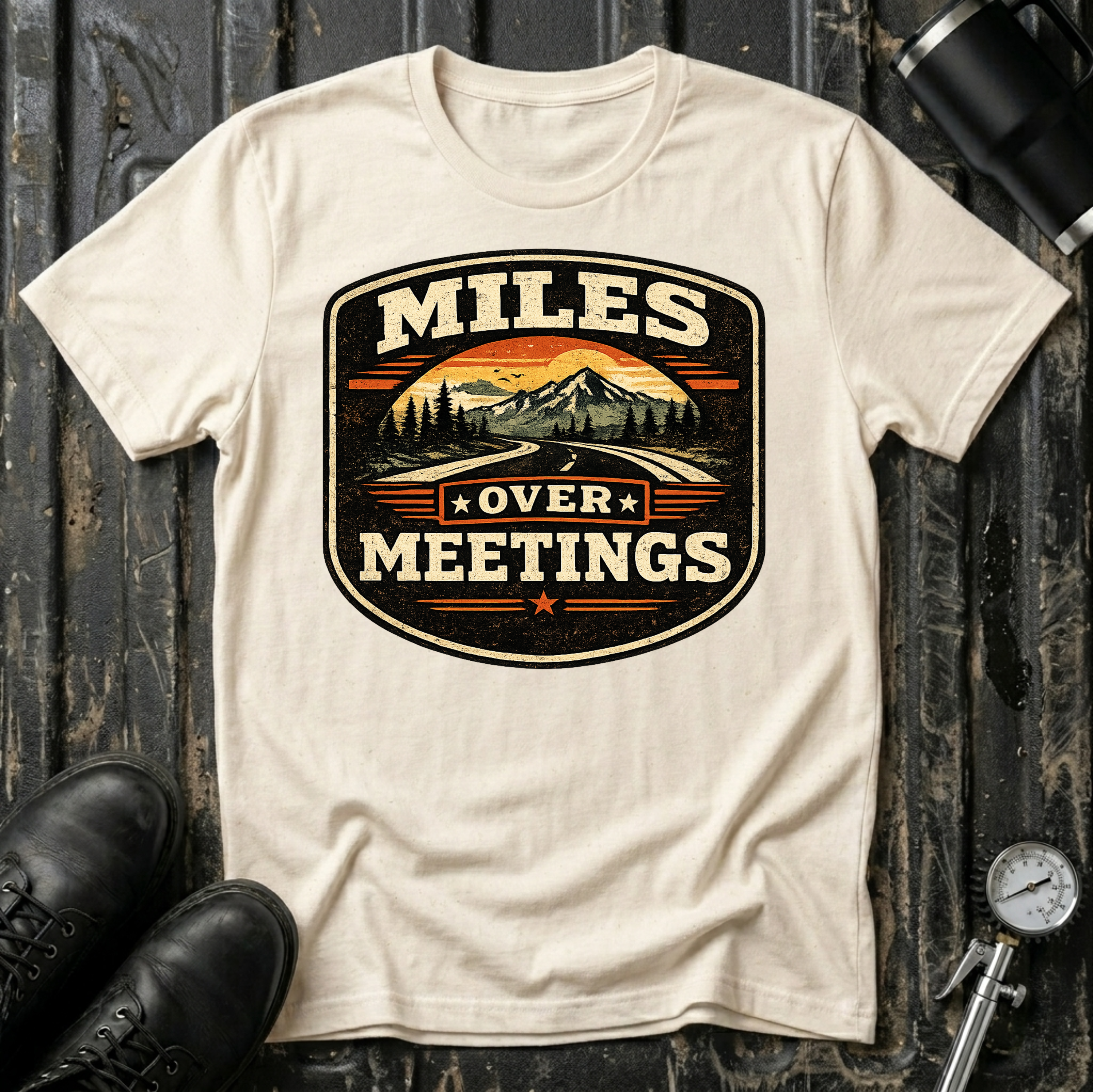 Miles Over Meeting T-shirt by The Riverstone Life on a natural Gildan Softstyle 64000 featuring a vintage highway and mountain design.