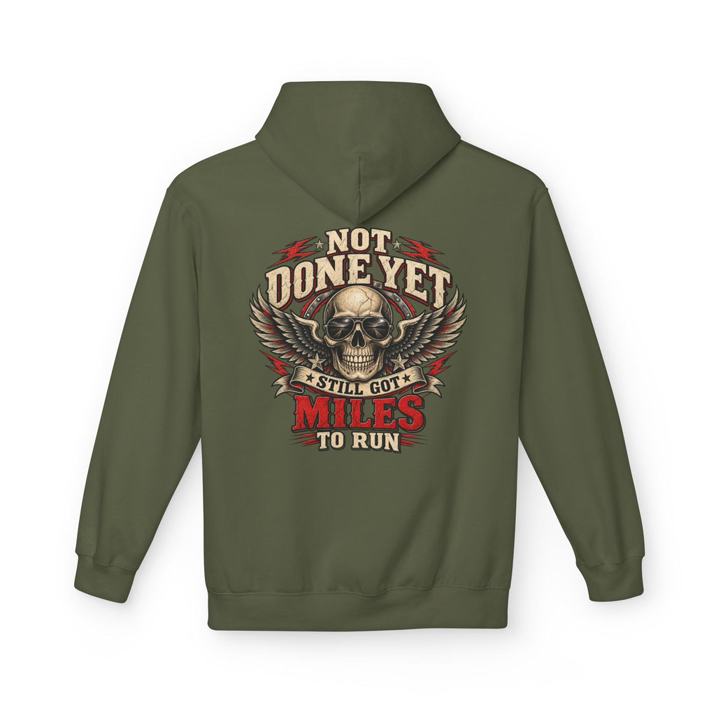 An military green pullover hoodie shown from the back, featuring a large graphic print of a skull with wings and the text 'NOT DONE YET', 'STILL GOT', 'MILES TO RUN' in cream, red, and black.
