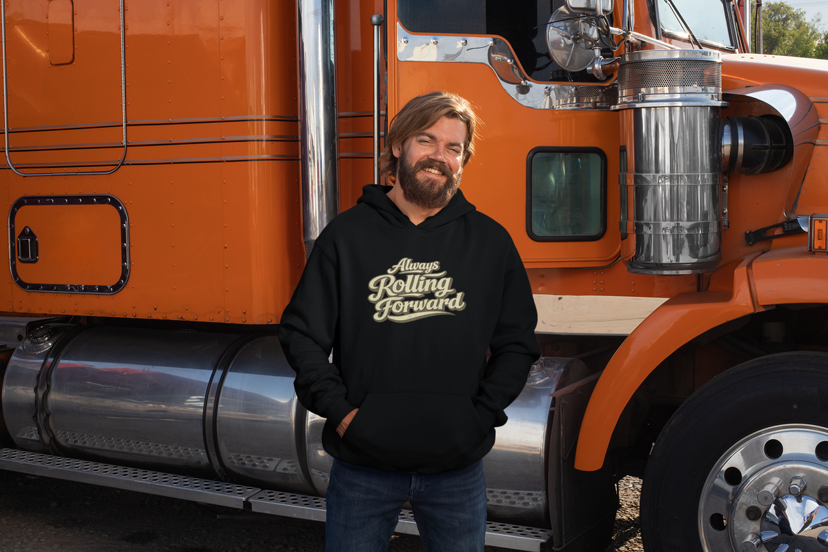 A man with a beard wearing a black hoodie with the text 'Always Rolling Forward' in white, standing in front of an orange semi-truck.