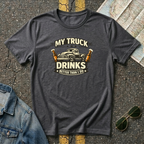 My Truck Drinks Better Than I Do T-shirt by The Riverstone Life on a dark heather Gildan Softstyle 64000 featuring a vintage pickup truck and humorous fuel themed design.