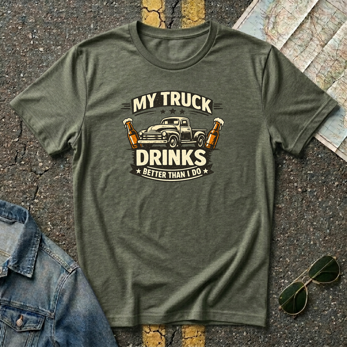 My Truck Drinks Better Than I Do T-shirt by The Riverstone Life on a military green Gildan Softstyle 64000 featuring a vintage pickup truck and humorous fuel themed design.