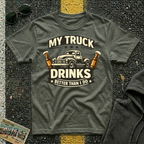 My Truck Drinks Better Than I Do T-shirt by The Riverstone Life on a military green Gildan Softstyle 64000 featuring a vintage pickup truck and humorous fuel themed design.