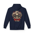 A navy blue hoodie shown from the back, featuring a large graphic print of a skull with wings and the text 'NOT DONE YET', 'STILL GOT', 'MILES TO RUN' in cream, red, and black.