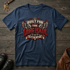 A navy graphic t-shirt laid flat on a rustic dark wood background, styled with keys, brown leather shoes, and a brown leather jacket. The t-shirt features a large graphic on the chest with wings, pistons, and the text 'BUILT FOR THE LONG HAUL MADE TO LAST'.