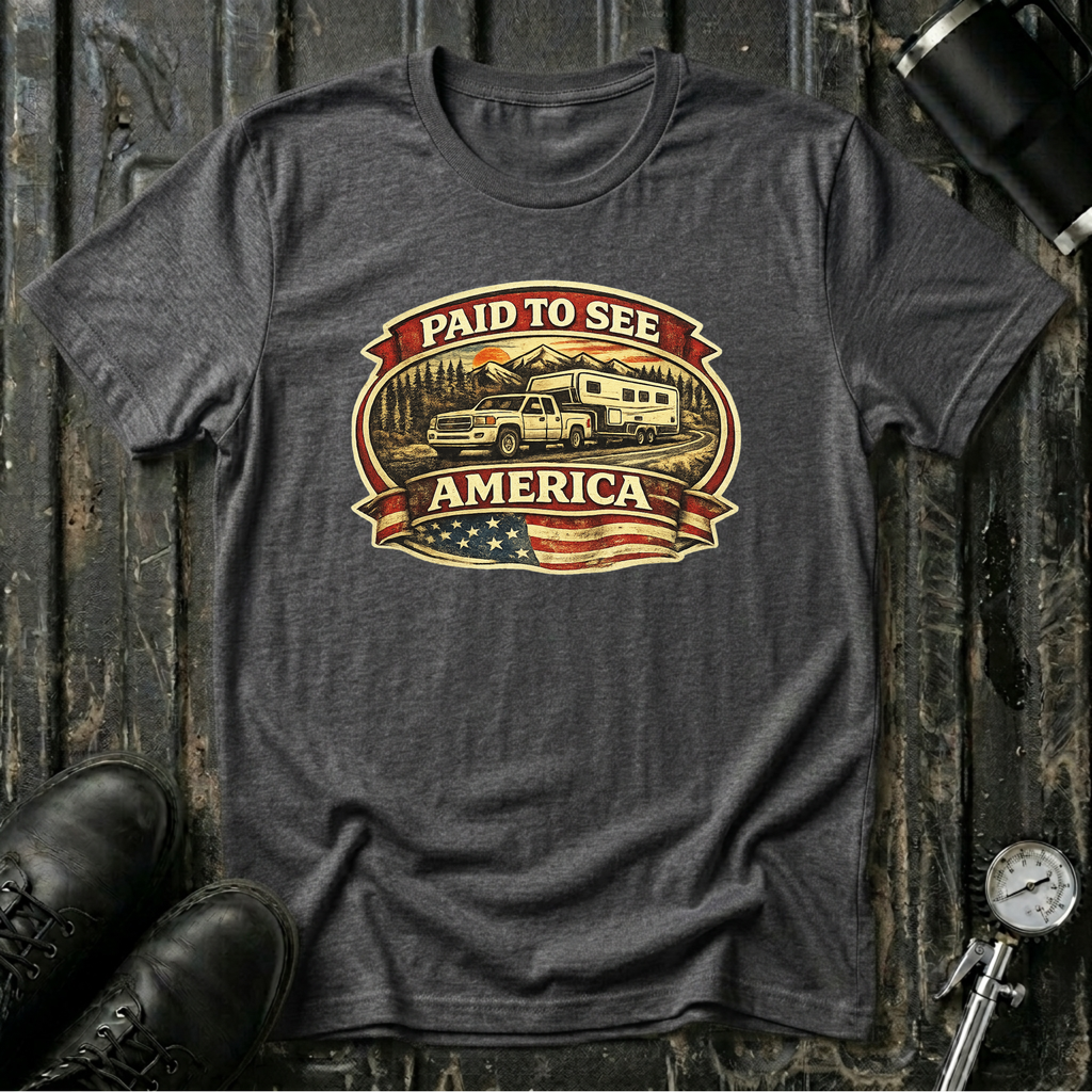 Dark heather RV Transport T-shirt featuring a white pickup truck towing a camper, an America flag, and a phrase "Paid to See America"