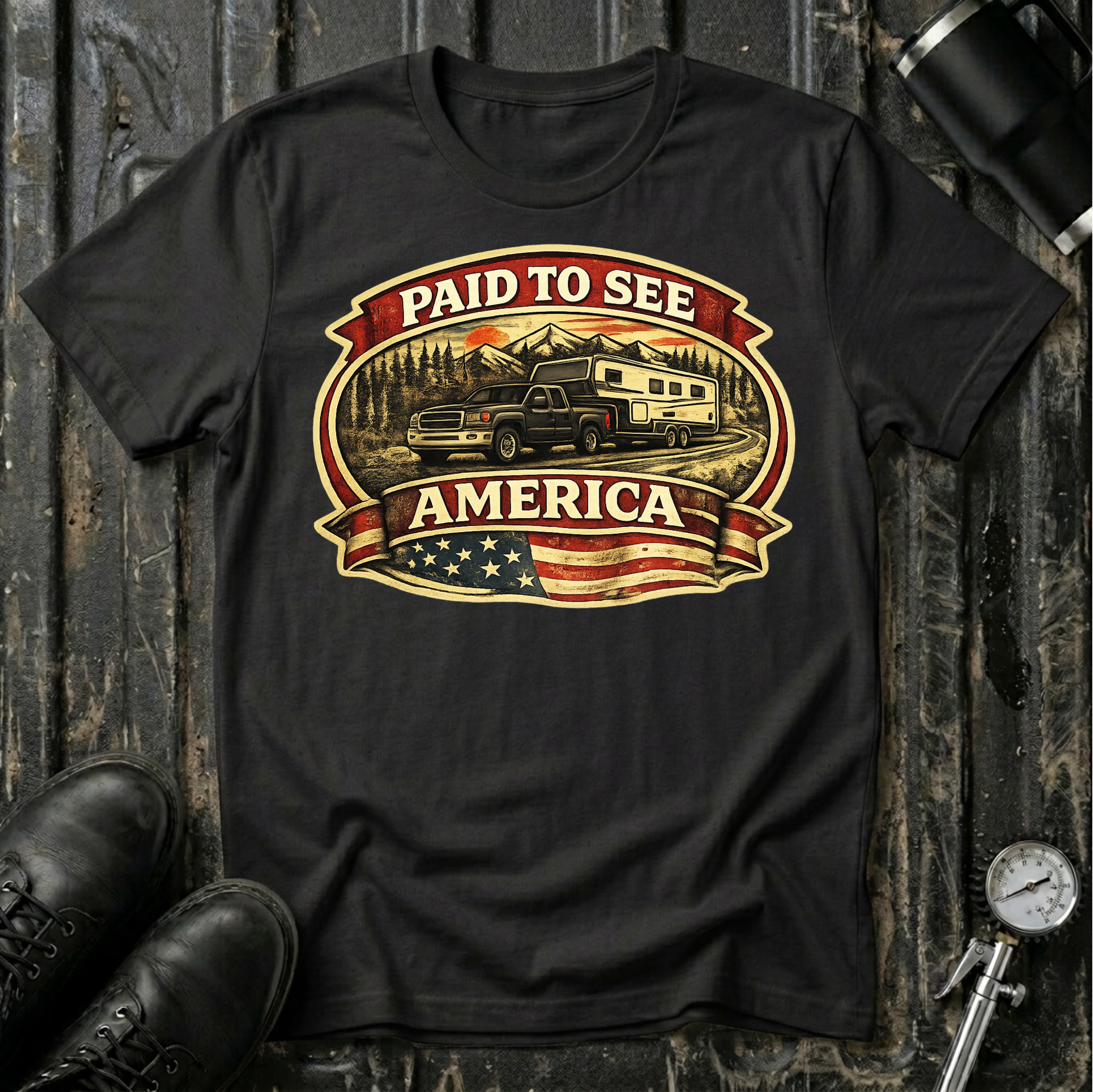 Paid to See America dark truck T-shirt by The Riverstone Life on a black Gildan Softstyle 64000 featuring a pickup truck hauling a fifth-wheel with an American flag and scenic landscape.