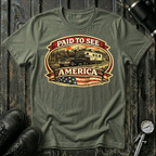 Paid to See America dark truck T-shirt by The Riverstone Life on a military green Gildan Softstyle 64000 featuring a pickup truck hauling a fifth-wheel with an American flag and scenic landscape.