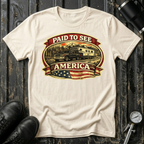 Paid to See America dark truck T-shirt by The Riverstone Life on a natural Gildan Softstyle 64000 featuring a pickup truck hauling a fifth-wheel with an American flag and scenic landscape.