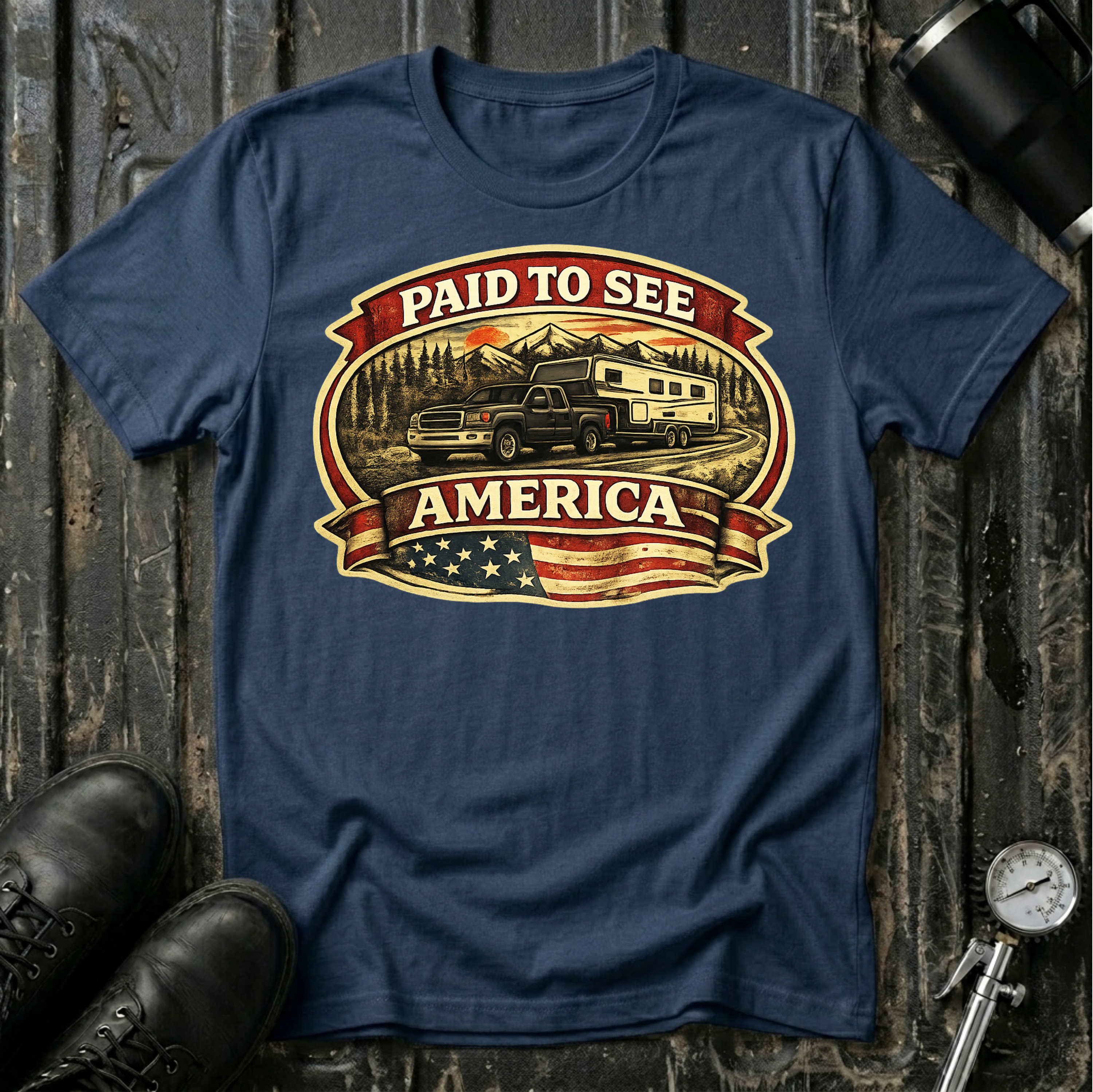 Paid to See America dark truck T-shirt by The Riverstone Life on a navy Gildan Softstyle 64000 featuring a pickup truck hauling a fifth-wheel with an American flag and scenic landscape.