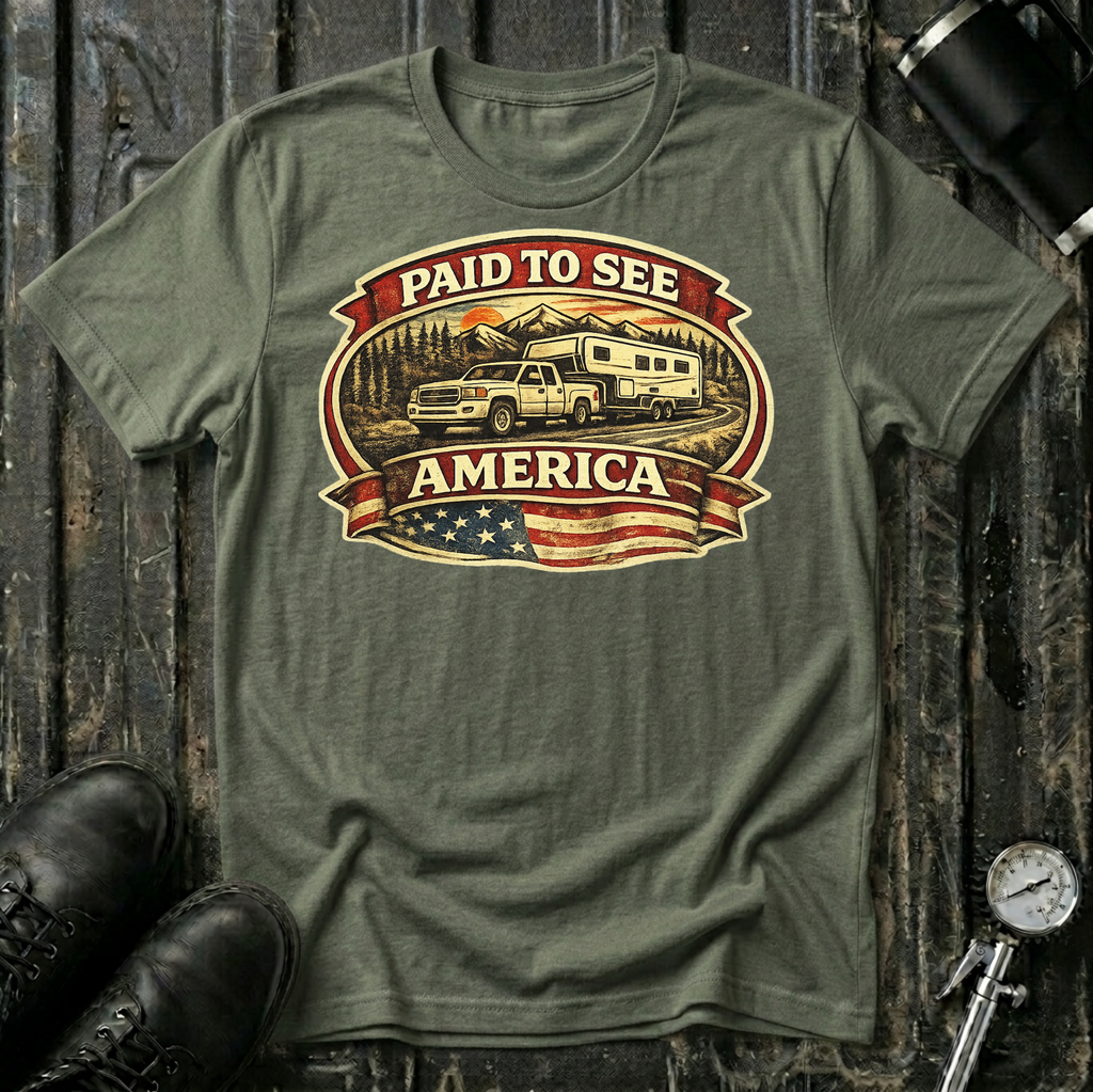 Paid to See America light truck T-shirt by The Riverstone Life on a military green Gildan Softstyle 64000 featuring a pickup truck hauling a fifth-wheel with an American flag and scenic landscape.