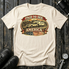 Paid to See America light truck T-shirt by The Riverstone Life on a natural Gildan Softstyle 64000 featuring a pickup truck hauling a fifth-wheel with an American flag and scenic landscape.
