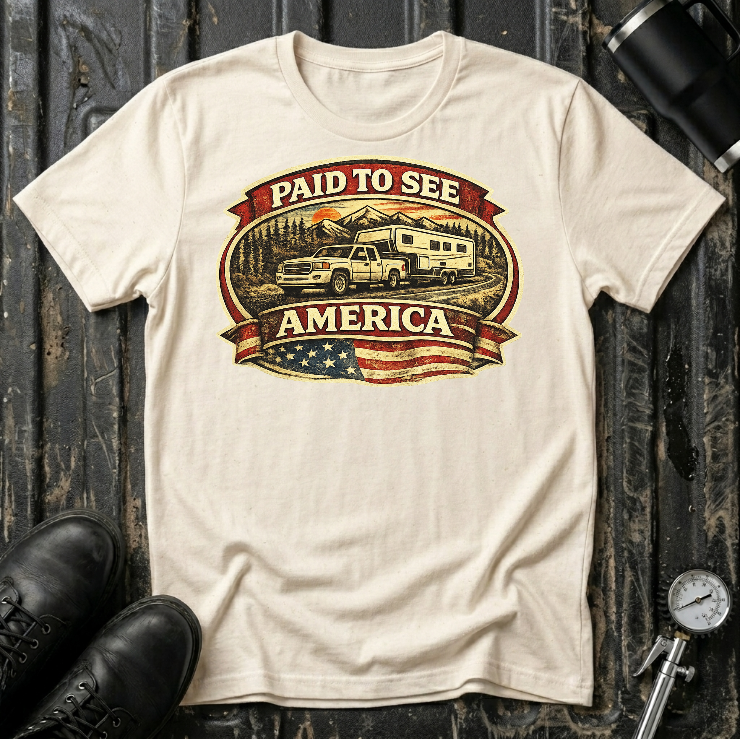 Paid to See America light truck T-shirt by The Riverstone Life on a natural Gildan Softstyle 64000 featuring a pickup truck hauling a fifth-wheel with an American flag and scenic landscape.