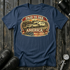 Paid to See America light truck T-shirt by The Riverstone Life on a navy Gildan Softstyle 64000 featuring a pickup truck hauling a fifth-wheel with an American flag and scenic landscape.