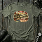 Military green  RV Transport T-shirt featuring a white pickup truck towing a camper, an America flag, and a phrase "Paid to See America"